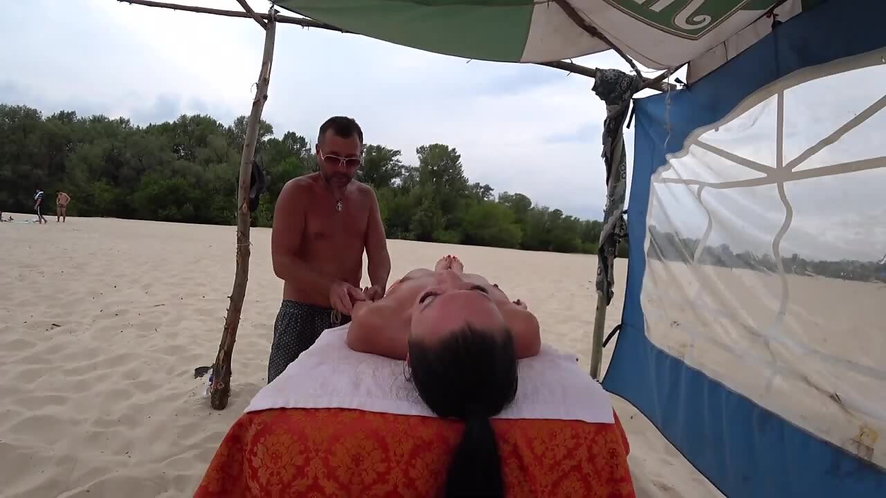 Hottest girl gets naked massage on beach image